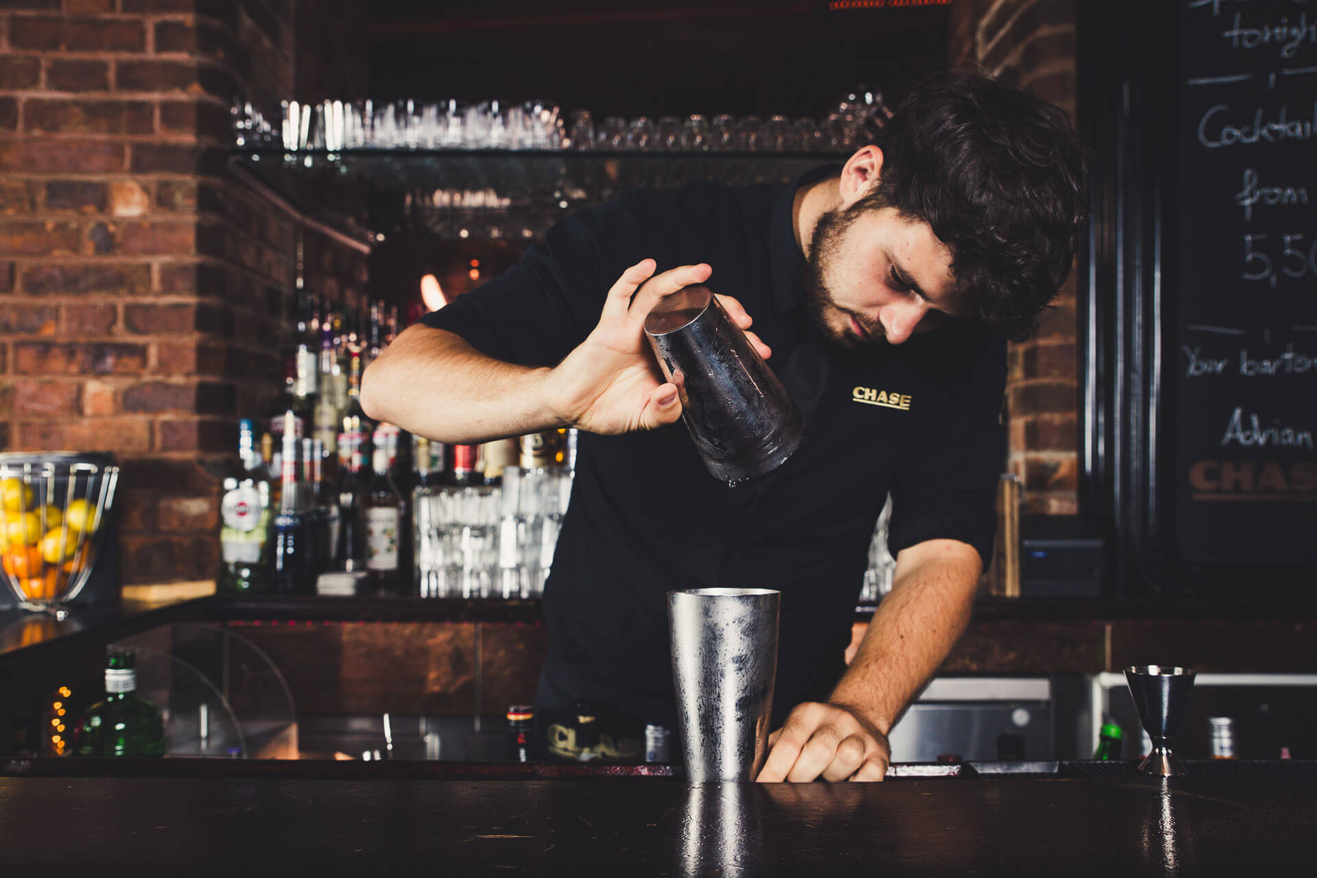 Barkeeper der CHASE Bar in Würzburg mixt einen Drink am Tresen