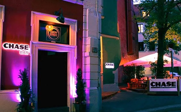 Entrada del CHASE Bar en la Bockgasse por la noche, iluminada en violeta