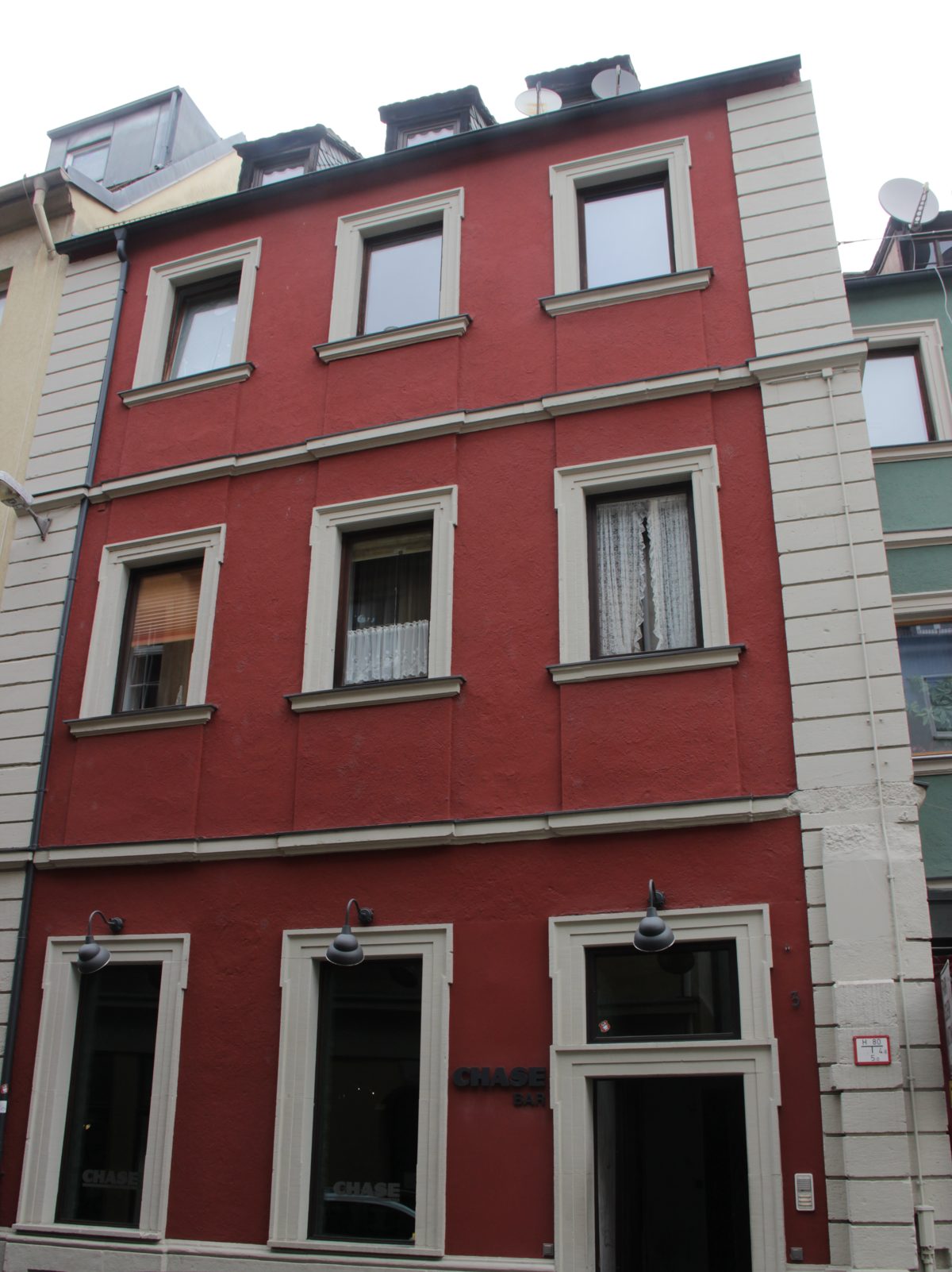 Rote Fassade des Hauses Bockgasse 3 in Würzburg mit dem Eingang der CHASE Bar im Erdgeschoss
